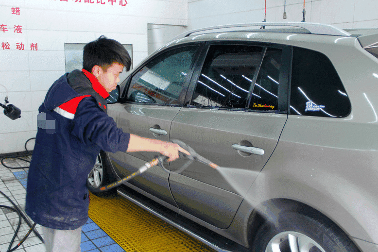 洗车店员工正在用高压清洗机洗车