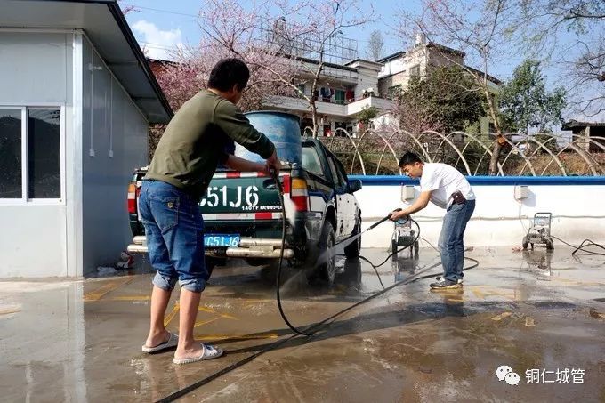 驾驶员用高压冲洗机对车辆进行冲洗